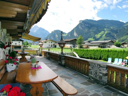 een balkon met een tafel en uitzicht op de bergen bij Apartment Heisenhaus - MHO680 by Interhome in Ramsau im Zillertal