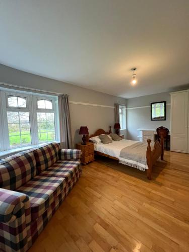 Woodville Lodge Guesthouse في كيلارني: غرفة معيشة مع سرير وأريكة