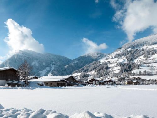 a village covered in snow with mountains in the background at Apartment Heisenhaus-1 by Interhome in Ramsau im Zillertal