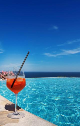 a drink in a glass next to a swimming pool at Pamperduto Country Resort in Porto Potenza Picena