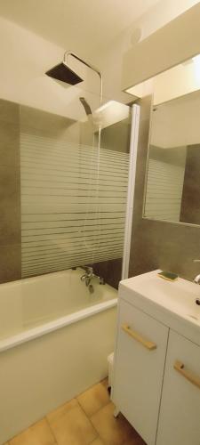 une salle de bain avec une baignoire et un lavabo et une baignoire dans l'établissement Superbe studio cabine, Cap d'Agde, au Cap d'Agde