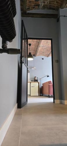 an open door in an empty room with a kitchen at Apartamenty STARA PIEKARNIA in Płock