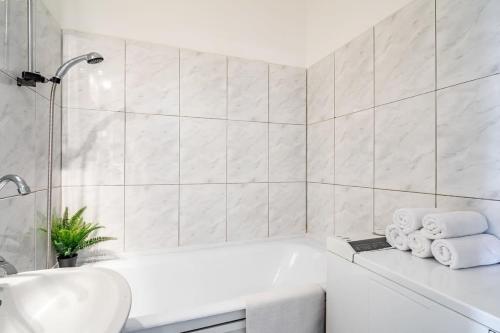 een witte badkamer met een bad en een wastafel bij Quiet home near the center in Boedapest