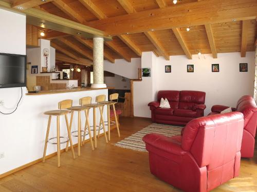 ローファーにあるApartment Nachbarbauer - LFE120 by Interhomeのリビングルーム(赤い家具付)、キッチン