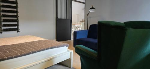 sypialnia z łóżkiem i niebieskim krzesłem w obiekcie Apartamenty STARA PIEKARNIA w mieście Płock