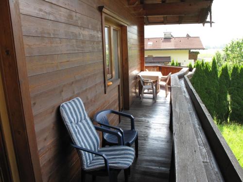un porche con 2 sillas y una mesa en una casa en Apartment Josef - ZAZ590 by Interhome en Aschau