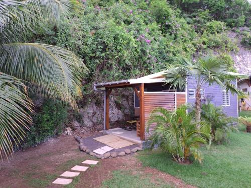 a small cabin with a porch in a garden at ZimZim in Le Gosier