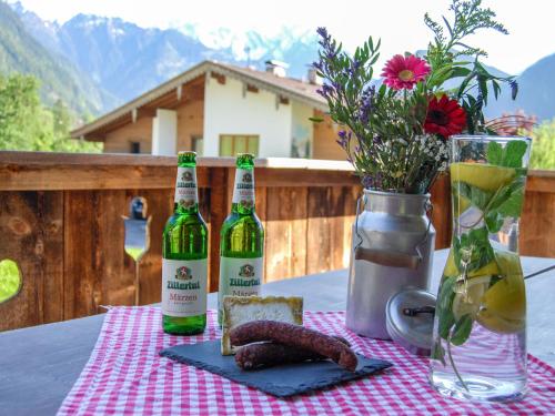 - une table avec deux bouteilles de vin et une assiette de nourriture dans l'établissement Holiday Home Geislerhütte - MHO685 by Interhome, à Ramsau im Zillertal