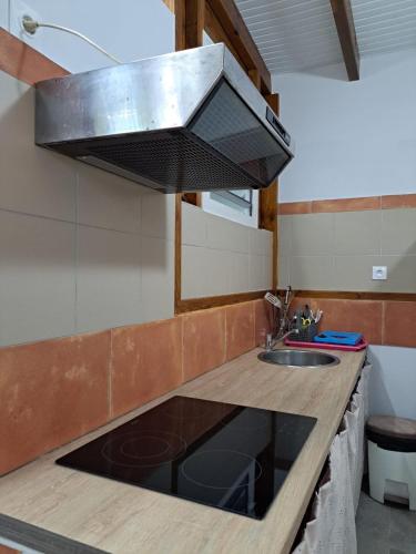 a kitchen counter with a sink and a hood at ZimZim in Le Gosier