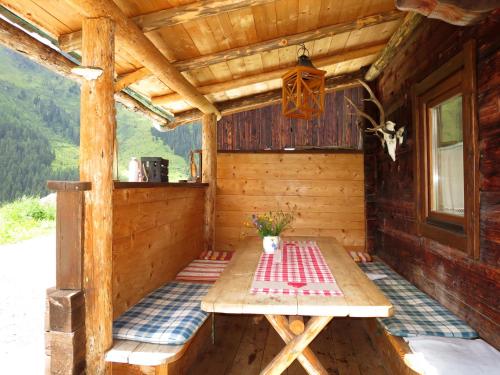 porche de una cabaña de madera con mesa de picnic en Chalet Simonhütte - MHO640 by Interhome en Hippach