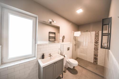 bagno con lavandino, servizi igienici e finestra. di ****Heviz Springs Apartments a Hévíz