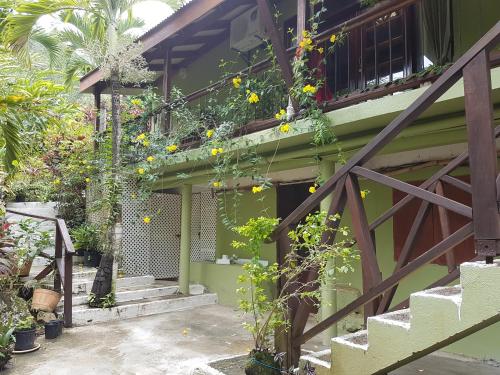 Hibiscus Valley Inn في Marigot: منزل عليه ورود صفراء