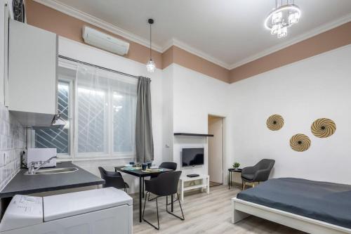 ein Schlafzimmer mit einem Bett und eine Küche mit einem Tisch in der Unterkunft NEW Central and Convenient in Budapest