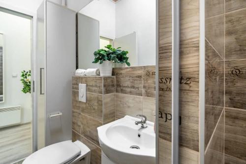 ein Badezimmer mit einem Waschbecken, einem WC und einem Spiegel in der Unterkunft NEW Central and Convenient in Budapest