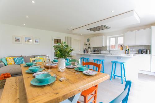 a kitchen and dining room with a wooden table and chairs at Kingsmead - Bracklesham Bay in Chichester