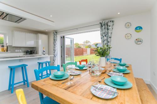 a kitchen and dining room with a wooden table and chairs at Kingsmead - Bracklesham Bay in Chichester