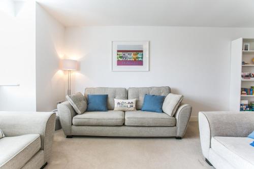 a living room with a couch and blue pillows at Kingsmead - Bracklesham Bay in Chichester