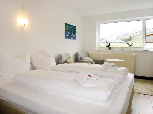 two beds in a room with white sheets at Apartment Tamerl - MHO160 by Interhome in Schwendau