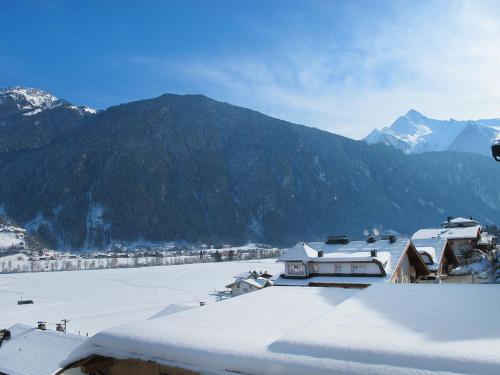 a town with snow covered roofs and a mountain at Apartment Tamerl-1 by Interhome in Schwendau