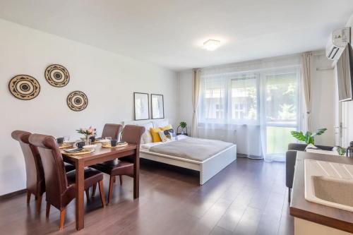 uma sala de estar com uma cama, uma mesa e cadeiras em Cute and convenient Apartment em Budapeste