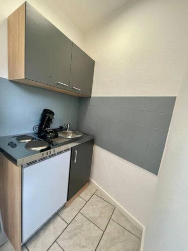 una pequeña cocina con fregadero y encimera en Stadtmitte: Schickes Apartment!, en Sinzig