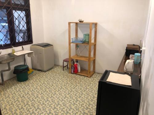 a bathroom with a sink and a toilet and a shelf at Little Cozy Homestay in Kota Bharu