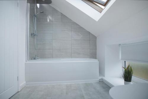 a white bathroom with a shower and a bath tub at Stylish Home near St Johns Chapel, Sleeps 6 in Saint Johns Chapel