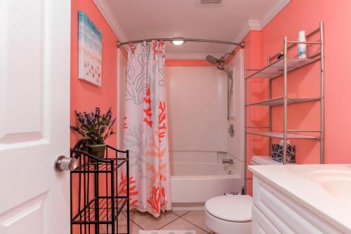 y baño con paredes de color naranja, aseo y bañera. en Oceanfront Custom and what a view of the ocean en Myrtle Beach