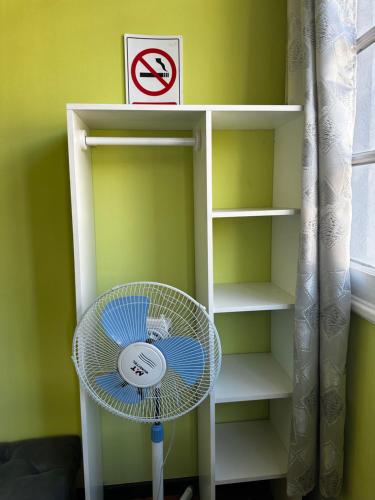 ein Bücherregal mit einem Ventilator in einem Zimmer in der Unterkunft Hostal Viva Chile Providencia - Bustamante in Santiago
