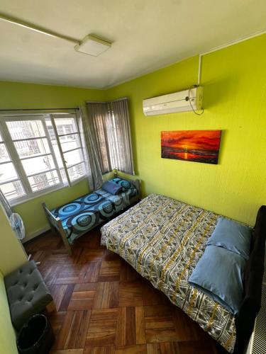 1 Schlafzimmer mit 2 Betten in einem Zimmer mit gelben Wänden in der Unterkunft Hostal Viva Chile Providencia - Bustamante in Santiago