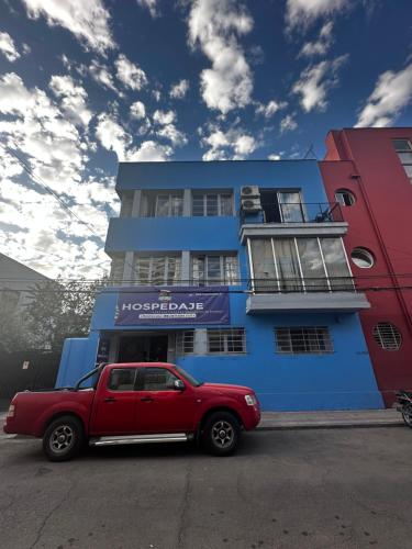 ein roter LKW, der vor einem blauen Gebäude parkt in der Unterkunft Hostal Viva Chile Providencia - Bustamante in Santiago