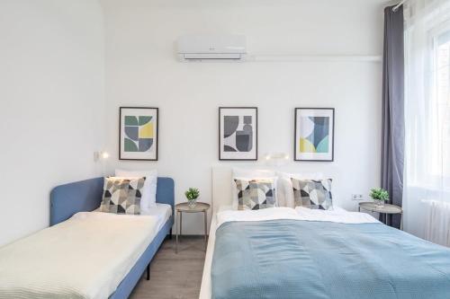 een slaapkamer met 2 bedden en 2 tafels bij Newly designed central studio in Boedapest