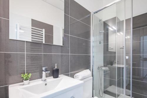 een badkamer met een witte wastafel en een douche bij Newly designed central studio in Boedapest