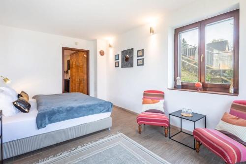 1 dormitorio con 1 cama, 1 silla y 1 ventana en Perfect relax en Somlószőlős