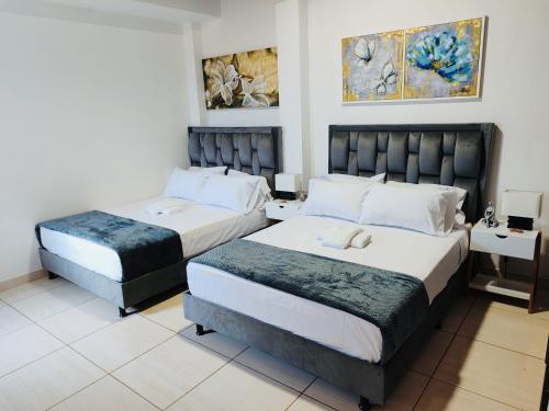 two beds in a hotel room with two at ApartaHostal Quintanilla in Villanueva