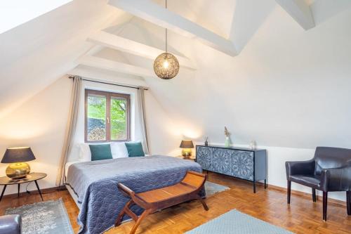 a bedroom with a bed and a chair and a window at Slow living - perfect vacation in Somlószőlős
