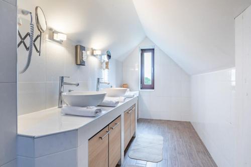 a bathroom with two sinks and white walls at Slow living - perfect vacation in Somlószőlős