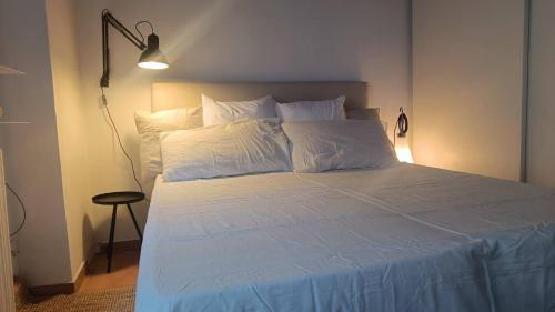 Bett mit weißer Bettwäsche und Kissen in einem Zimmer in der Unterkunft Tortona Design Navigli Milan in Mailand