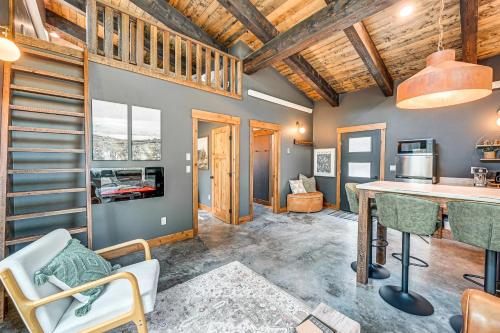 a kitchen and living room with wooden ceilings at Modern Polson Cabin with Deck Near Flathead Lake! in Polson
