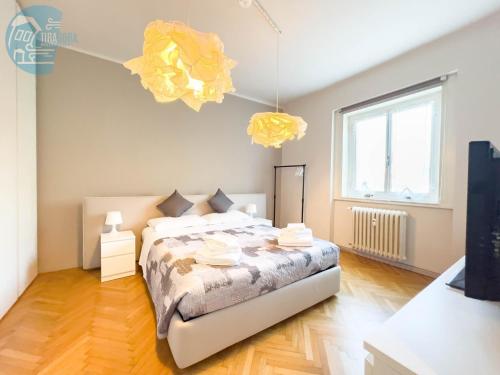 a bedroom with a bed and two yellow lights at Viale Miramare 123/1 Tirabora Short Rent in Trieste