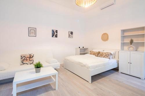 una camera bianca con un letto e un divano di Central Cozy Home a Budapest