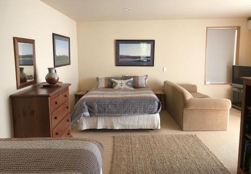 a bedroom with a bed and a couch and a chair at Sargood Splendour - Wanaka Holiday Home in Wanaka