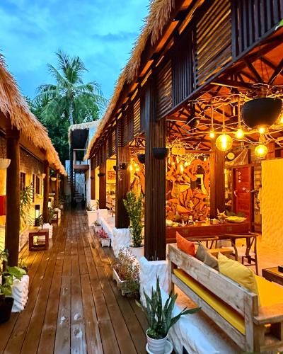 a porch of a resort with benches and tables at Atholhu Residence in Fehendhoo