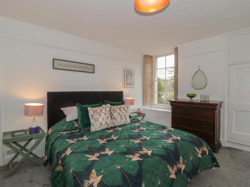 a bedroom with a bed with a green comforter at Southbank in Bath