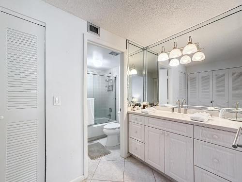 a white bathroom with a sink and a toilet at Beach Front Condo In Paradise Marco Island in Marco Island