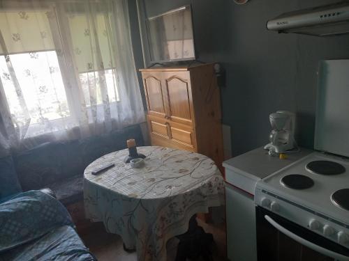 uma pequena cozinha com uma mesa e um fogão em Люлин хаус em Sófia