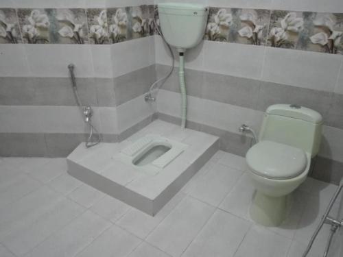 a bathroom with a toilet and a sink at Al Sadiq Guest House in Murree
