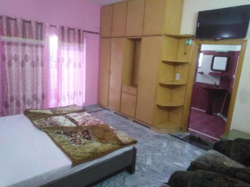 a bedroom with a bed and a tv in it at Al Sadiq Guest House in Murree