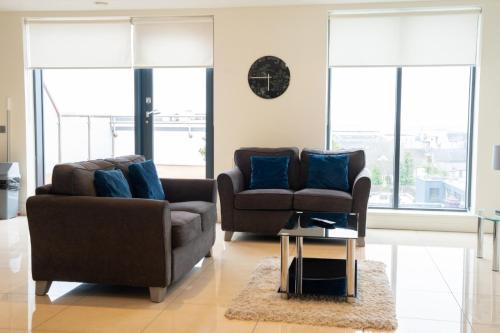 a living room with two couches and a table at The Western Citypoint Apartments in Galway