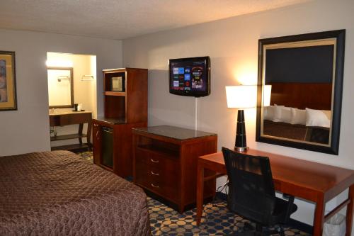 Habitación de hotel con 1 dormitorio con escritorio y 1 cama en Dayspring Extended Stay en Greensboro